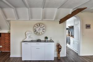 a kitchen with a clock on the wall and a counter at Ferienwohnung BEST in Hünxe