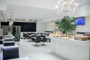 a restaurant with chairs and a bar with a buffet at Ker Recoleta Hotel in Buenos Aires