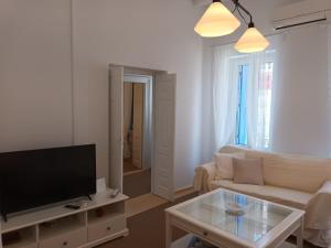 a living room with a couch and a tv at Tenok Boutique Home in Tinos