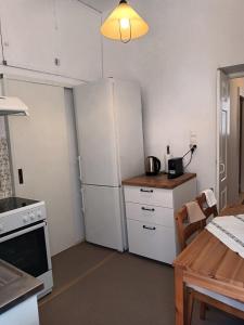 a kitchen with a white refrigerator and a table at Tenok Boutique Home in Tinos