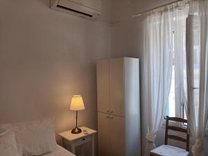 a bedroom with a white cabinet and a bed and a lamp at Tenok Boutique Home in Tinos