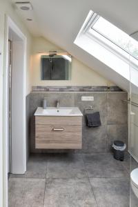 uma casa de banho com um lavatório e uma clarabóia em Ferienwohnung BEST em Hünxe
