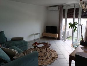 un soggiorno con divano e tavolo di Appart' cosy climatisé à 10' des plages et de Sète a Frontignan