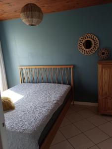 - une chambre avec un lit et un mur bleu dans l'établissement Appart' cosy climatisé à 10' des plages et de Sète, à Frontignan