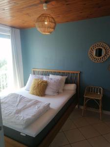 una camera con un letto con una parete blu di Appart' cosy climatisé à 10' des plages et de Sète a Frontignan