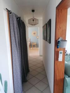 un couloir menant à un salon avec des rideaux dans l'établissement Appart' cosy climatisé à 10' des plages et de Sète, à Frontignan