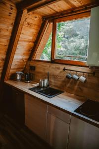 una cocina con fregadero y una ventana en una cabaña en Mesa Summer House, en Zakrzewo