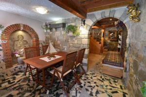 a dining room with a table and a stone wall at Vila Nada Piran in Piran