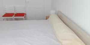 1 cama blanca en una habitación con 2 sillas en L'Isard, en Pierrefitte-Nestalas