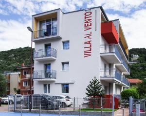 a white building with a sign on it at Hotel Villa Al Vento in Nago-Torbole