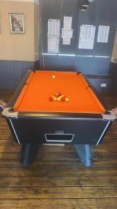 an orange pool table with balls on top of it at The Welshman’s Arms in Pembrokeshire