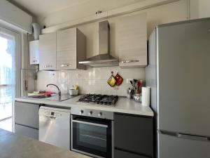 a kitchen with a stove and a refrigerator at Stazione a 400 metriTeds Home in Melegnano