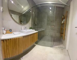 W łazience znajduje się prysznic, umywalka i lustro. w obiekcie Queen Apartments Belgrade Waterfront w Belgradzie