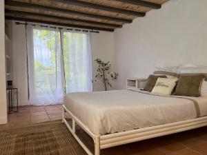 a bedroom with a bed and a large window at Domaine Royal Quercy in Monclar-de-Quercy