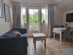 Bergland apartment 23 - close to the center of Kragerø في كراغرو: غرفة معيشة مع أريكة وطاولة