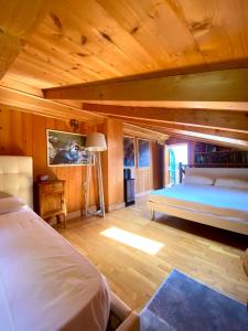 1 dormitorio con 2 camas en una habitación con paredes de madera en La Dimora Degli Olivi, en Galbiate
