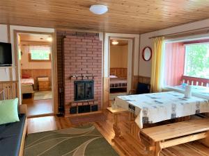 een kamer met een open haard en een bed in een kamer bij Lappalaisen lomamökit Suviranta in Puumala