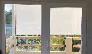 2 ventanas con persianas blancas en una habitación en Cabañas Monte Hermoso en Monte Hermoso