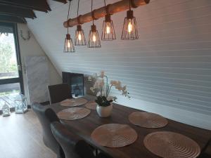 uma sala de jantar com uma mesa com cadeiras e luzes em Chalet 32 em Nagel