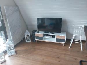 a living room with a flat screen tv on a cabinet at Chalet 32 in Nagel