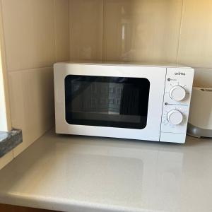 a white microwave sitting on top of a counter at Alojamento dos Redondos in Fernao Ferro +37 photos