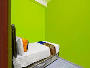 Habitación verde con 1 cama en una habitación en SPOT ON 92786 Homestay Barokah, en Gresik