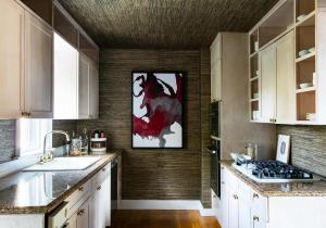 una cocina con armarios blancos y una pintura roja en la pared en The Swain House at 21 Broad, en Nantucket