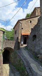 a stone building with a bridge next to a road at LA VECCHIA STALLA in Varano
