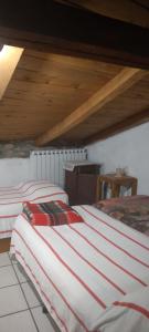 two beds in a room with a wooden ceiling at LA VECCHIA STALLA in Varano