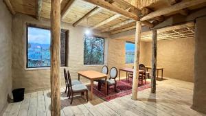 a room with a table and chairs and windows at KyzArt Hotel & Horse Tours in Bagysh