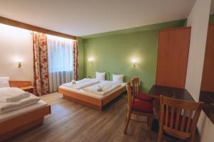 a bedroom with two beds and a table and chairs at PhiliPop-Up Hostel in Scharnitz