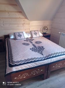 a bedroom with a bed in a room with wooden walls at Domki ,,Goramiba'' in Jurgów