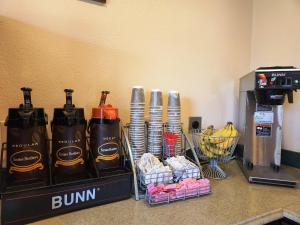a counter with a coffee machine and a bunch of drinks at Highland Inn in Arlington