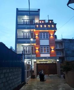 加德滿都的住宿－Peace Homestay，一座高大的建筑,旁边灯火通明