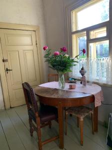 una mesa con un jarrón de flores encima en House of silence, 