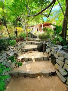 a garden with rocks and trees and a stone wall at Villa Ilo Komba in Nosy Komba