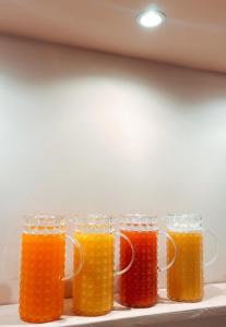 four glasses of orange juice sitting on a shelf at Albergo Degli Amici in Monterosso al Mare