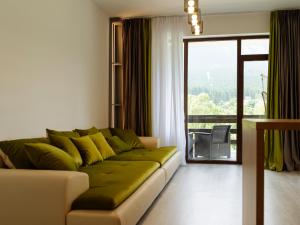 a living room with a couch and a large window at Nature Loft by the river in Buşteni