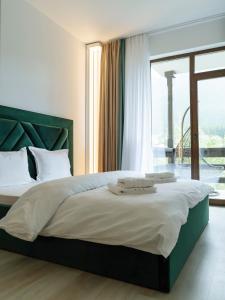 a bedroom with a large bed with a large window at Nature Loft by the river in Buşteni