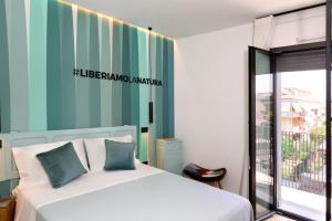 ein Schlafzimmer mit einem Bett mit einer grün-weiß gestreiften Wand in der Unterkunft La Sentina Experience in San Benedetto del Tronto