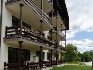 a building with balconies and flowers on it at Nature Loft by the river in Buşteni