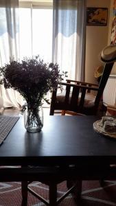 un vaso di fiori su un tavolo in soggiorno di Gite de la Piegerie a Courgenard