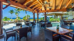 an outdoor restaurant with tables and chairs and the ocean at Halii Kai 20D in Waikoloa
