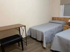een kamer met 2 bedden, een tafel en een bureau bij La Andana in Macastre