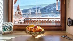 a bowl of fruit on a table in front of a window at VisitZakopane - Giewont View Apartment in Kościelisko