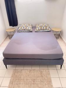 een bed in een kamer met twee kussens erop bij STUDIO VUE ROCHER DU DIAMANT in Le Marin