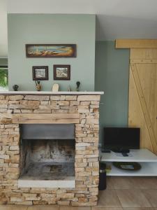 Una sala de estar con chimenea de piedra con monitor. en Eco Residence, en Ribaritsa 24 fotos más