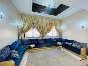 Sofá azul en la sala de estar con ventanas en The Villa avec piscine 4 chambres, en Marrakech