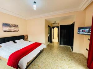 1 dormitorio con 1 cama grande y TV de pantalla plana en The Villa avec piscine 4 chambres, en Marrakech