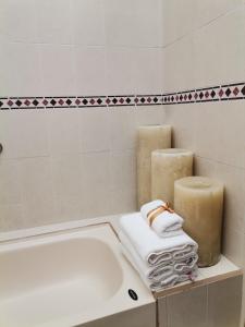 uma casa de banho com banheira e 2 velas e toalhas em Posada Real de Chiapas em San Cristóbal de Las Casas